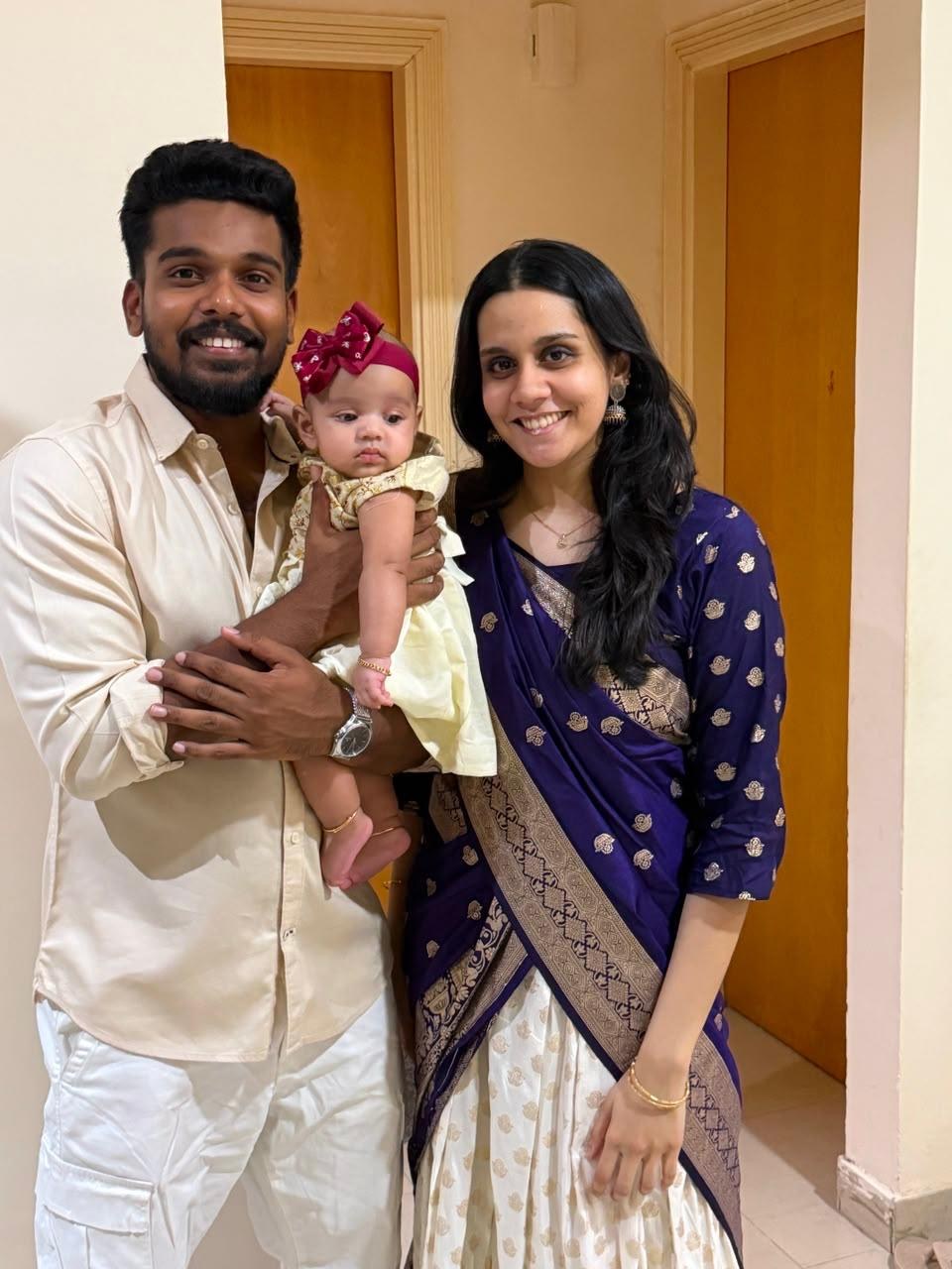 Ameera, her husband and their baby smiling together